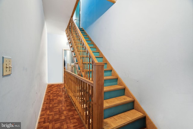 staircase with dark parquet floors