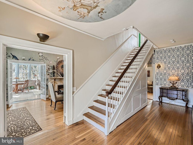 stairs featuring light hardwood / wood-style flooring and ornamental molding