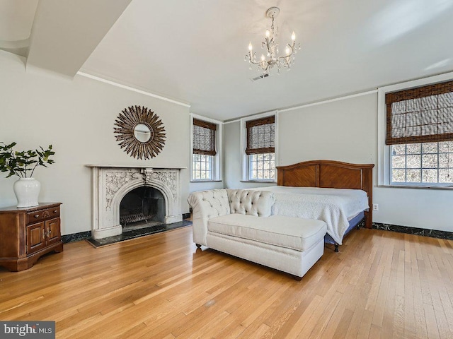 bedroom featuring multiple windows, an inviting chandelier, and light hardwood / wood-style flooring