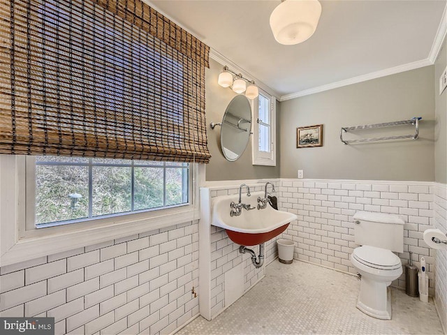 bathroom featuring tile walls, toilet, sink, ornamental molding, and tile flooring