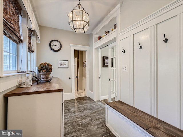 mudroom featuring an inviting chandelier and dark wood-type flooring