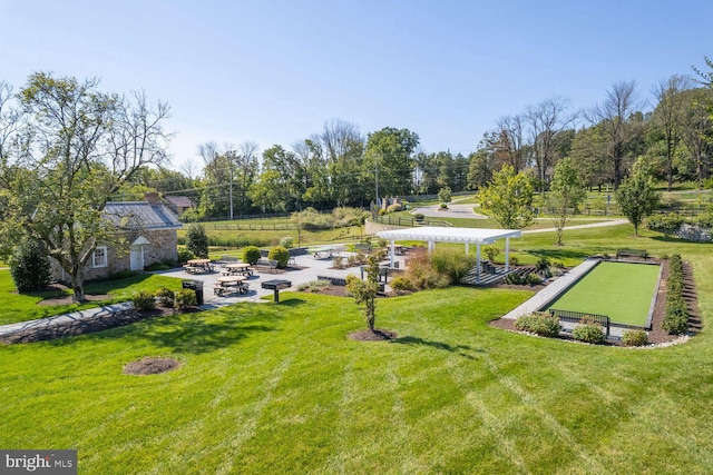 view of property's community with a pergola and a lawn