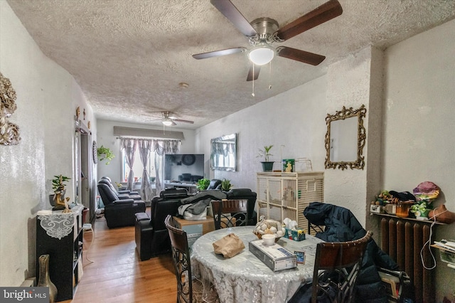 dining area with ceiling fan, a textured ceiling, and light wood-type flooring