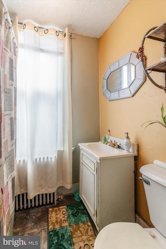 bathroom featuring tile floors, toilet, a textured ceiling, and vanity