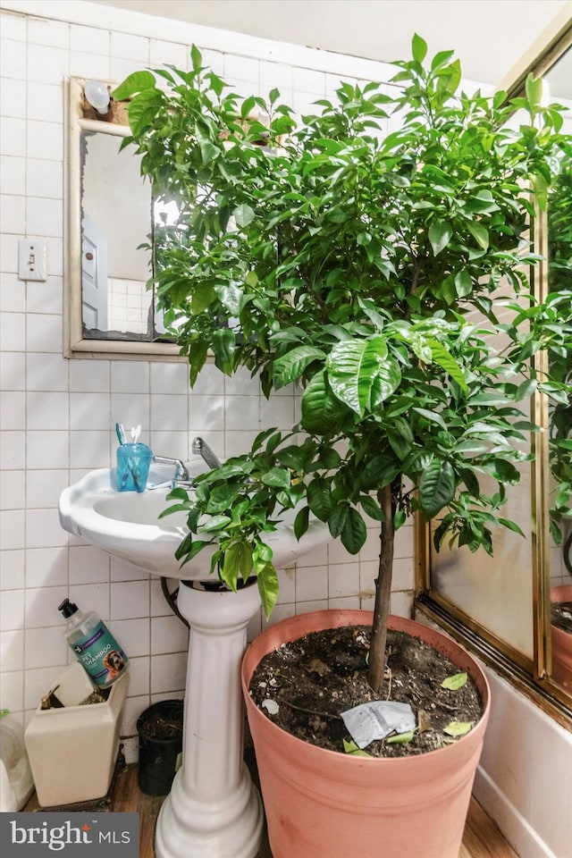 bathroom with tile walls, tasteful backsplash, and wood-type flooring