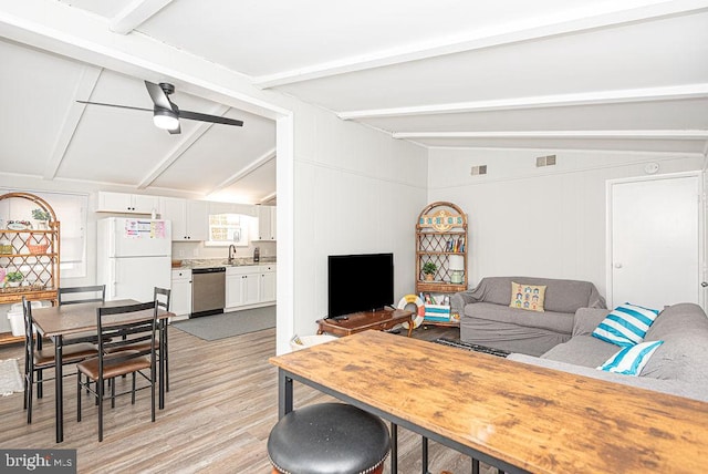 living room featuring ceiling fan, lofted ceiling with beams, light wood-type flooring, and sink