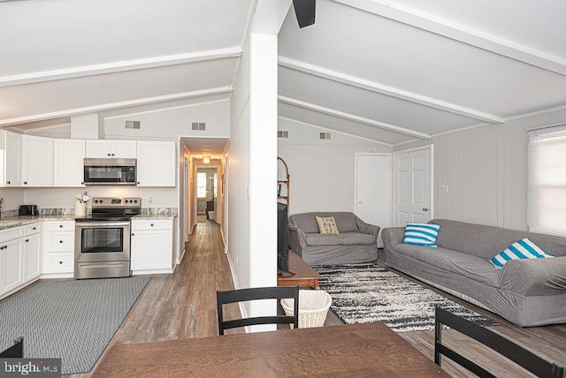 living room featuring lofted ceiling with beams and wood-type flooring