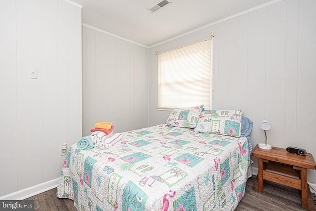 bedroom with dark wood-type flooring and ornamental molding