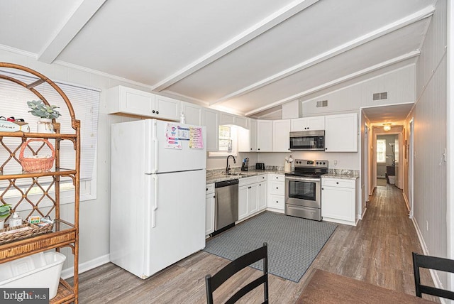 kitchen with lofted ceiling with beams, stainless steel appliances, wood-type flooring, and white cabinets