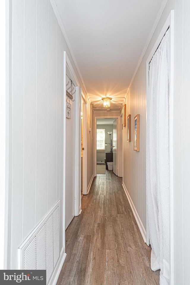 corridor with crown molding and dark wood-type flooring