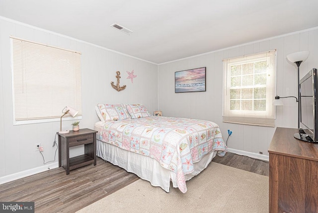 bedroom with hardwood / wood-style floors and crown molding