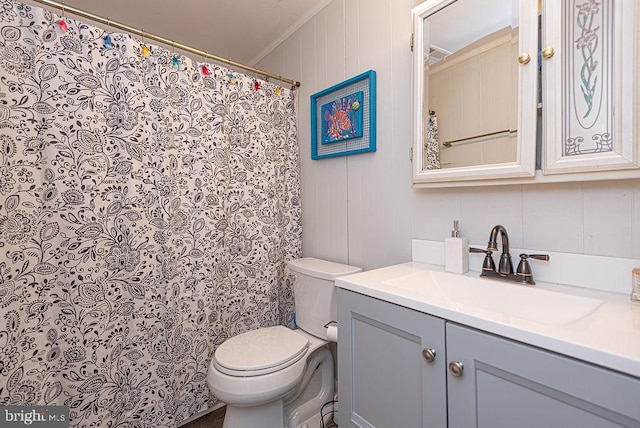 bathroom featuring toilet, ornamental molding, and vanity