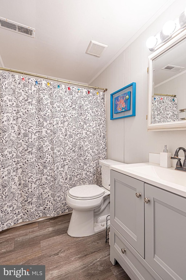 bathroom featuring crown molding, toilet, vanity, and wood-type flooring