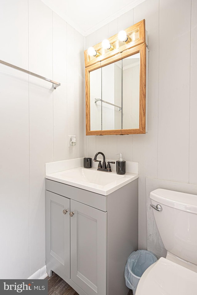 bathroom featuring toilet, ornamental molding, and large vanity