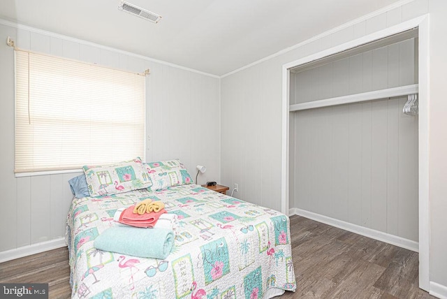 bedroom featuring crown molding, a closet, and dark hardwood / wood-style flooring