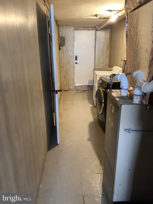 basement with washer and clothes dryer and wood walls