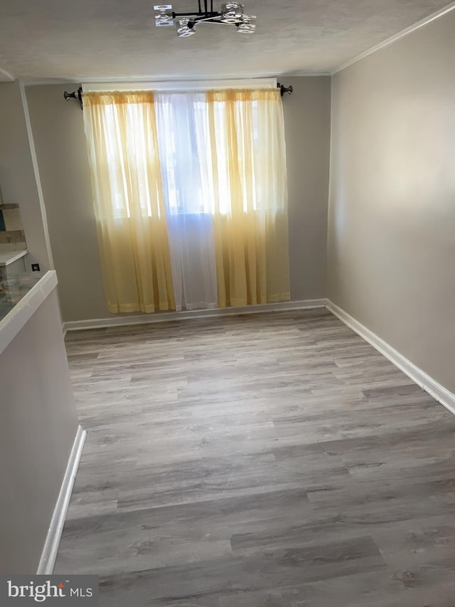 spare room with hardwood / wood-style floors and ornamental molding