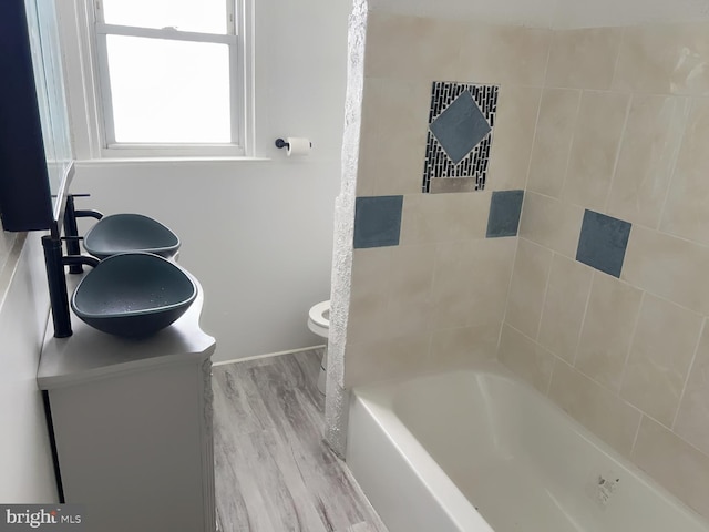 bathroom featuring a tub to relax in, vanity, hardwood / wood-style flooring, and toilet