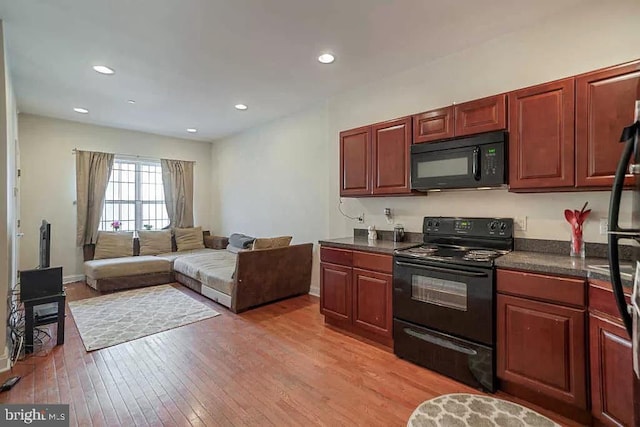 kitchen with light hardwood / wood-style floors and black appliances