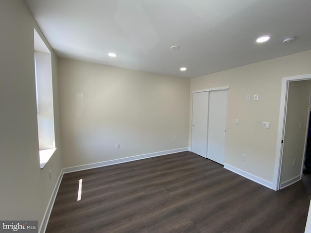 unfurnished room with dark wood-type flooring