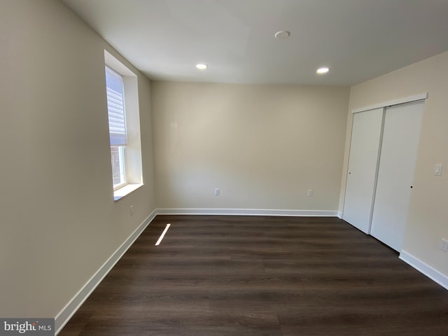 unfurnished bedroom with a closet and dark wood-type flooring