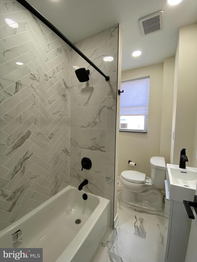 full bathroom featuring tiled shower / bath, toilet, tile flooring, and vanity