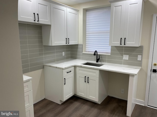 kitchen featuring light stone counters, dark hardwood / wood-style flooring, white cabinetry, and sink