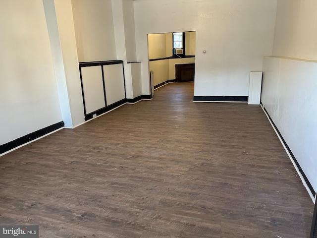 unfurnished room with dark wood-type flooring