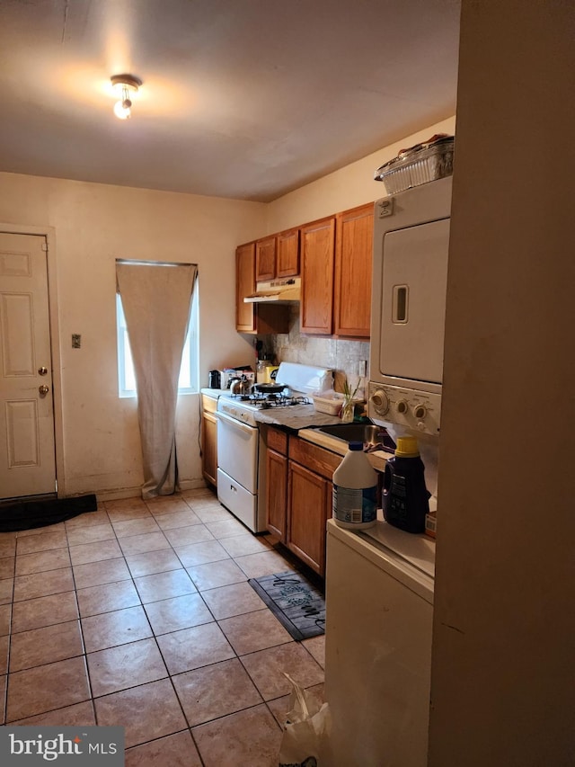 kitchen with light tile flooring, tasteful backsplash, and white gas range oven