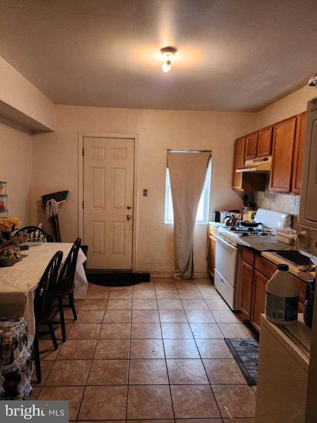 kitchen with gas range gas stove and light tile floors