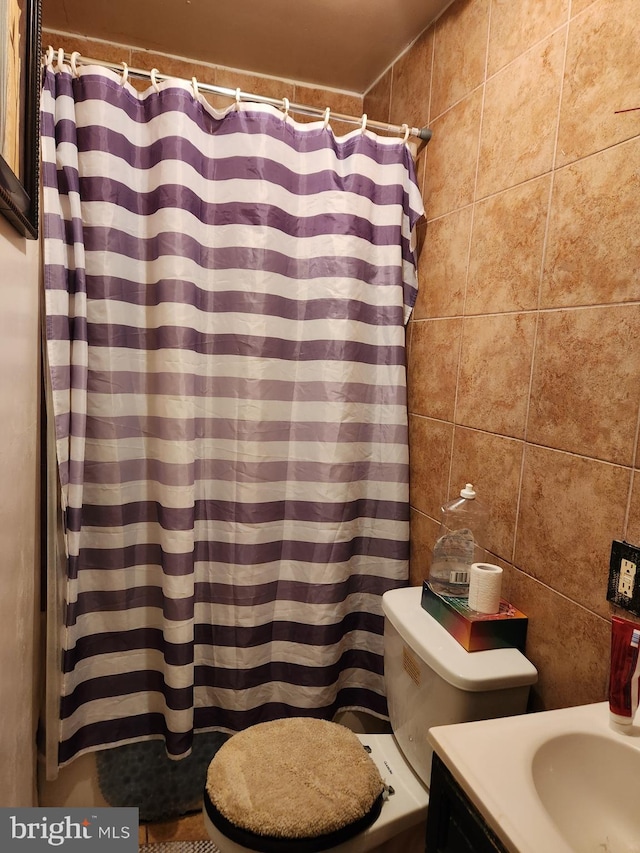 full bathroom featuring tile walls, toilet, vanity, and shower / bath combo with shower curtain