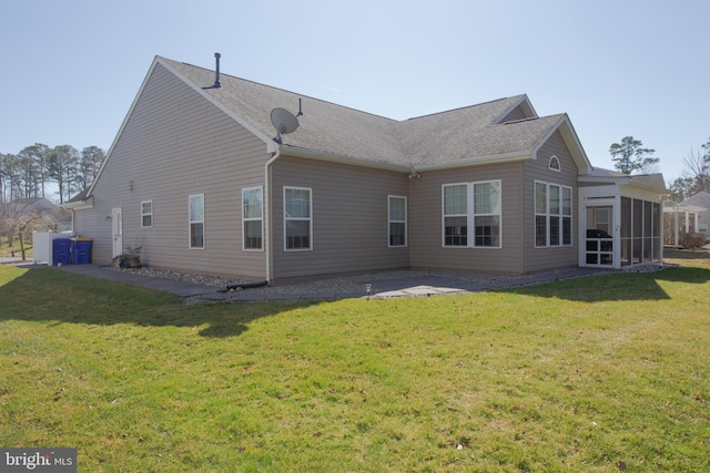 back of house featuring a lawn and a sunroom