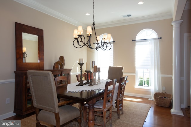 dining space with a notable chandelier, ornamental molding, dark wood-type flooring, and ornate columns