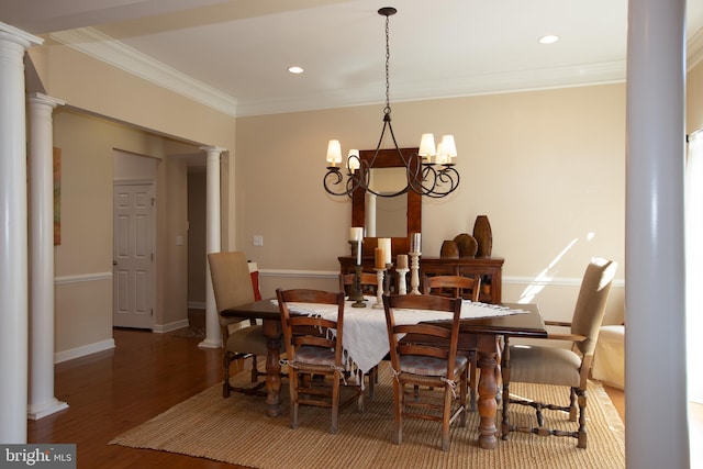 dining room featuring decorative columns, a notable chandelier, dark hardwood / wood-style floors, and crown molding