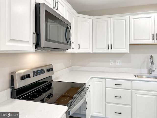 kitchen with white cabinetry, appliances with stainless steel finishes, and sink