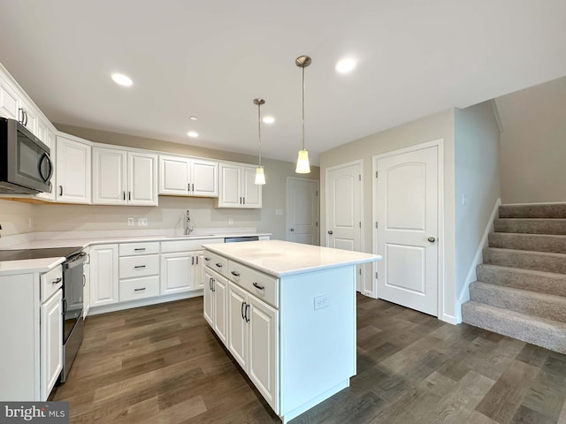 kitchen featuring a kitchen island, stainless steel range with electric cooktop, decorative light fixtures, white cabinets, and dark wood-type flooring