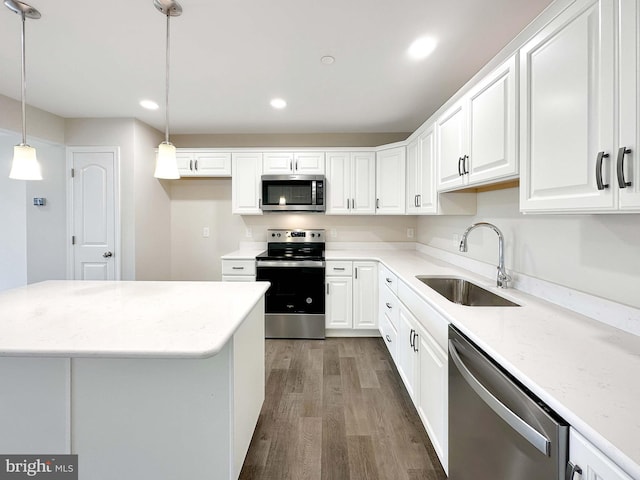 kitchen with white cabinetry, decorative light fixtures, stainless steel appliances, and sink