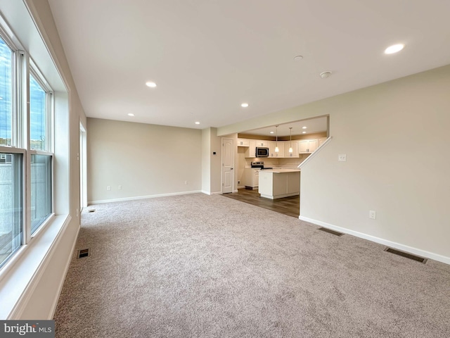 unfurnished living room with dark colored carpet