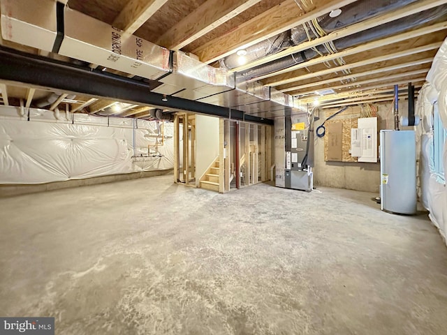 basement featuring electric panel, heating unit, and water heater