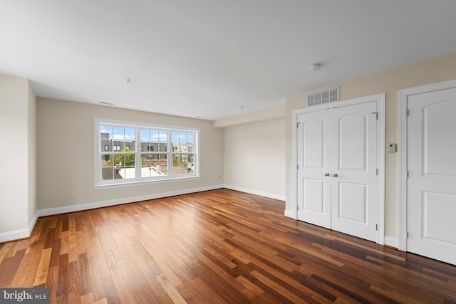 unfurnished room with dark wood-type flooring