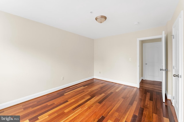 empty room with dark hardwood / wood-style flooring