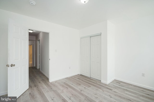 unfurnished bedroom featuring a closet and light hardwood / wood-style flooring