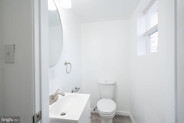 bathroom with toilet and vanity with extensive cabinet space