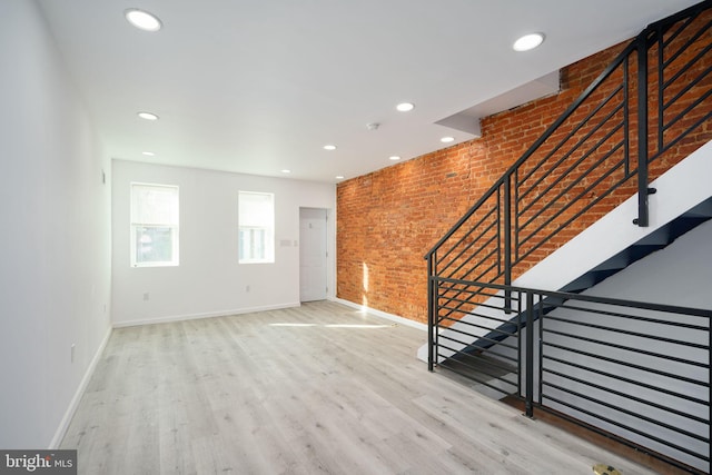 interior space with brick wall and light wood-type flooring