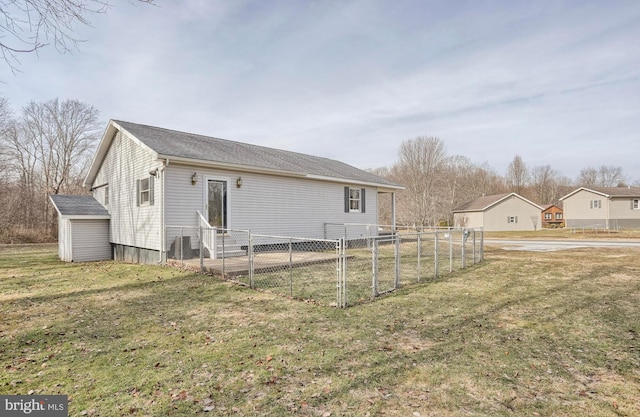 rear view of property with a lawn and an outdoor structure