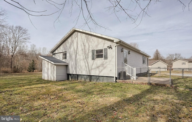 rear view of house featuring a lawn and an outdoor structure