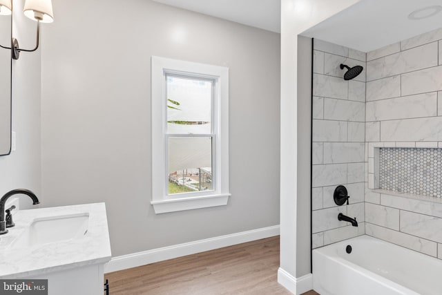 bathroom with vanity, wood-type flooring, and tiled shower / bath combo