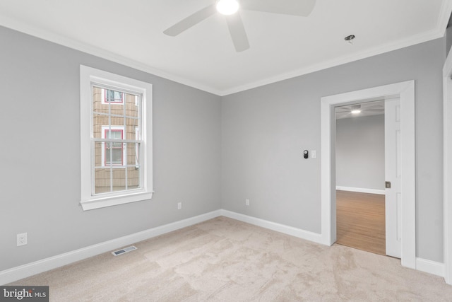 carpeted spare room featuring ceiling fan and ornamental molding