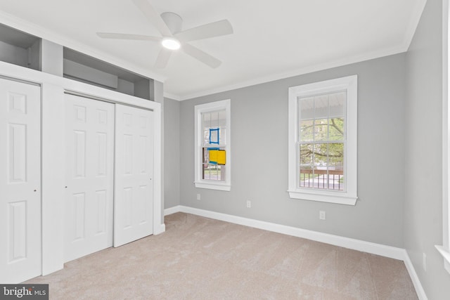 unfurnished bedroom with ceiling fan, ornamental molding, and light carpet