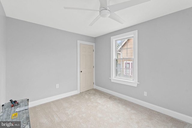 carpeted spare room featuring ceiling fan